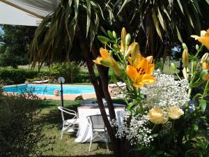a table and some flowers next to a pool at La cesa country B&B in Scandriglia
