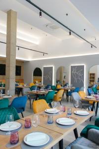 a restaurant with wooden tables and colorful chairs at Hotel Lupus Silva in Villardeciervos