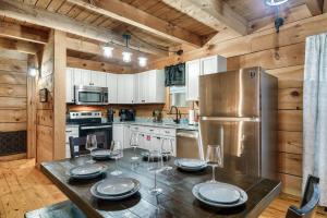 a kitchen with a table with plates and wine glasses at Smokies Log Cabin Hot Tub, Fire Pit & Arcade in Townsend