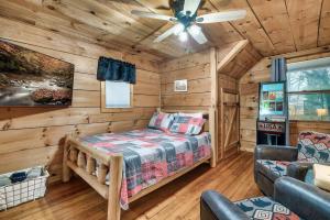 a log cabin bedroom with a bed and a ceiling fan at Smokies Log Cabin Hot Tub, Fire Pit & Arcade in Townsend