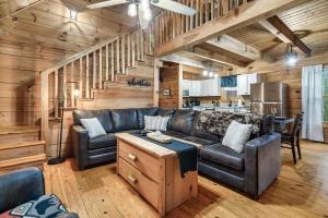 a living room with a couch and a kitchen at Smokies Log Cabin Hot Tub, Fire Pit & Arcade in Townsend +31 photos