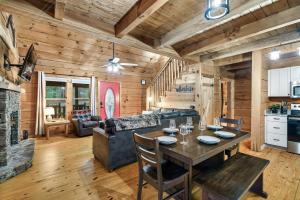 a dining room and living room with a table in a cabin at Smokies Log Cabin Hot Tub, Fire Pit & Arcade in Townsend