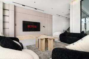 a living room with a tv on a wall at شاليهات وفلل سُبات in Half Moon Bay