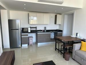 a kitchen with a refrigerator and a table and a couch at Penthouse El Gouna, Hurghada in El Gouna