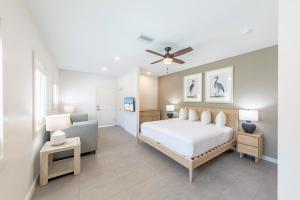 a bedroom with a white bed and a couch at The Palmetto Inn in Boca Grande