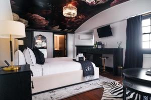 a bedroom with a white bed with a painting on the ceiling at Garden Gables in Lenox