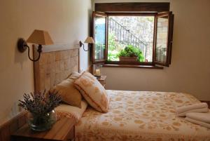 a bedroom with a bed and a window at Apart con piscina Lebanes Picos de Europa in Torices