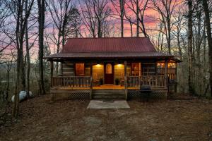a small cabin in the woods with a red roof at Dog friendly, Hot Tub & Near Tuckaleechee Caverns in Townsend