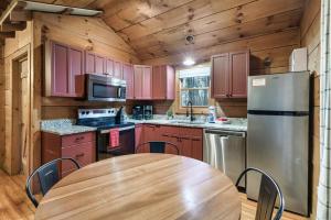 a kitchen with a wooden table and a refrigerator at Dog friendly, Hot Tub & Near Tuckaleechee Caverns in Townsend +28 photos