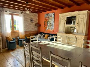 a dining room with a table and a couch at Gîte LES GOUTTES 2 chambres 2 SDB in Courzieu