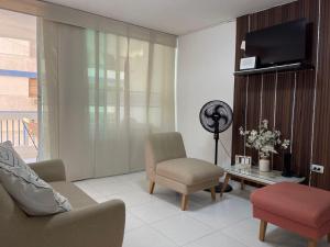 a living room with a couch and a chair and a fan at Apartamento karey 506 in Santa Marta