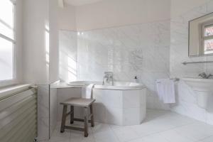 a white bathroom with a tub and a sink at Monastery Garden Prague in Prague +62 photos