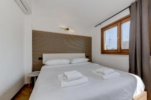 a bedroom with a white bed with towels on it at Anna Home View in Sirmione