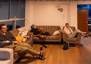 three people sitting on couches in a living room at Mariandes Hostel in Huaraz