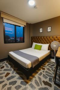 a bedroom with a large bed with a large window at Hotel AirPort Pereira in Pereira