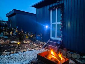 a fire pit in front of a building at night at Panorama Lupilor in Coleşti