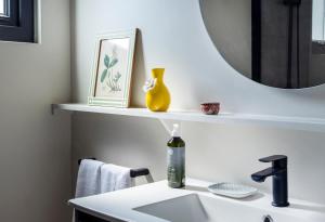 a bathroom with a sink and a mirror on a shelf at Pueblo La Dehesa in Santiago