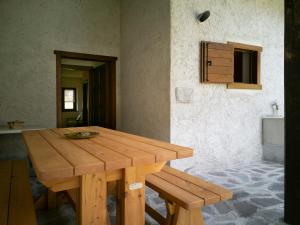 a wooden table with a bench in a room at Casa Davide Valdaone in Daone +37 photos