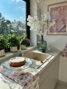 a kitchen sink with a cake sitting on a towel at Wichrowy Domek Nowy Targ - Podhale - Tatry - Gorce - Balia in Nowy Targ