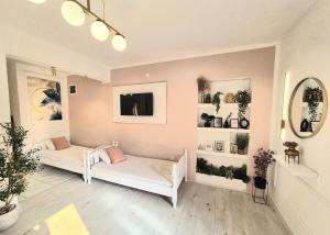 a living room with two white couches and a tv at Apartmani Una Igalo in Igalo
