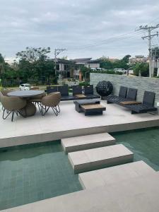 a patio with a table and chairs and water at Cozy 1BR with Balcony, Sea View and Pool - Fast WiFi - Snug Sanctuary in Talisay