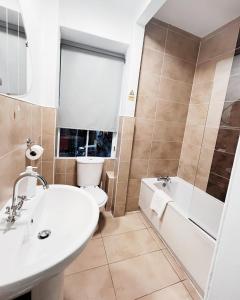 a bathroom with a sink and a tub and a toilet at Old Town Castle Apartment in Edinburgh