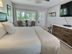 a bedroom with a large white bed and a table at Kennebunkport Motor Lodge in Kennebunkport