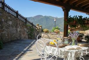 a table and chairs on a patio with mountains in the background at Apart con piscina Lebanes Picos de Europa in Torices +29 photos