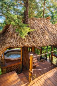 a large wooden deck with a thatched roof at OMGHAT Glamping in El Peñol