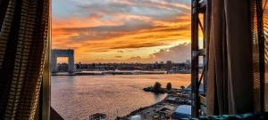 a view of a river from a window with a sunset at Faralda Crane Hotel in Amsterdam