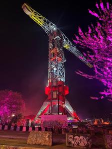 a crane lit up at night with purple lights at Faralda Crane Hotel in Amsterdam