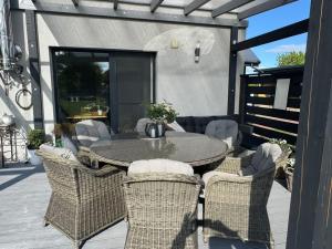 a patio with a table and chairs on a deck at Domek z jacuzzi Studnica 39 in Studnica