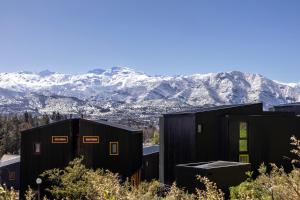 a group of shipping containers with mountains in the background at Pueblo La Dehesa in Santiago +26 photos