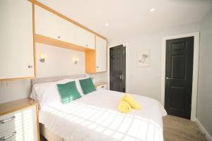 a bedroom with a white bed with a yellow towel on it at 1 Bedroom Lodge By Travel Lets Self Catering Accommodation Rathmullen With Hot Tub in Ramelton