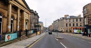 a car driving down a city street with buildings at New Town Residence in Edinburgh