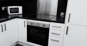 a kitchen with white cabinets and a microwave at New Town Residence in Edinburgh +2 photos
