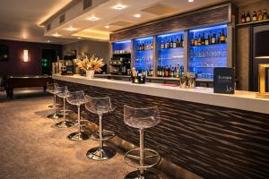 a row of stools at a bar with wine bottles at Hotel Europa in Quiberon