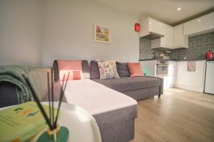 a living room with a couch and a kitchen at 1 Bedroom Lodge By Travel Lets Self Catering Accommodation Rathmullen With Hot Tub in Ramelton