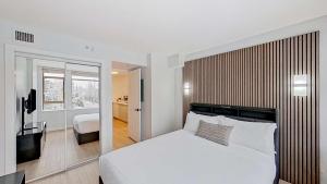 a bedroom with a large white bed and a television at Cascade Lodge in Whistler +98 photos
