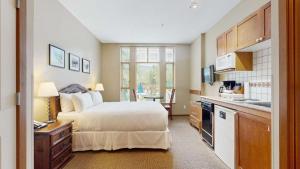 a hotel room with a bed and a kitchen at Cascade Lodge in Whistler
