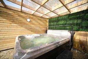 a jacuzzi tub in a wooden building at 1 Bedroom Lodge By Travel Lets Self Catering Accommodation Rathmullen With Hot Tub in Ramelton +39 photos
