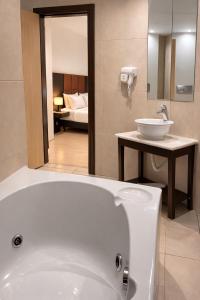 a bathroom with a bath tub and a sink at INOH Athens Hotel in Athens +44 photos