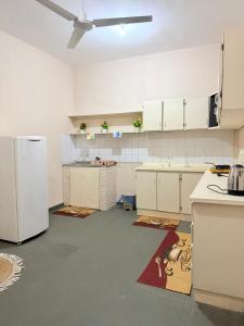 a kitchen with white cabinets and a white refrigerator at GuestHouse Encanto del Centro 2 in Encarnación