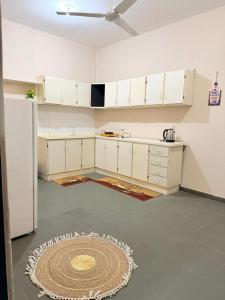 a kitchen with white cabinets and a rug on the floor at GuestHouse Encanto del Centro 2 in Encarnación