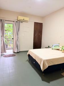 a bedroom with a large bed and a window at GuestHouse Encanto del Centro 2 in Encarnación