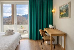 a bedroom with a desk and a bed and a window at Lakefront Bled - Rooms & Apartments in Bled