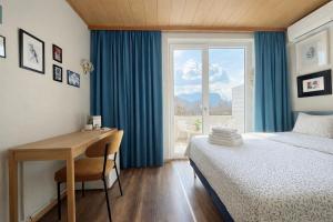 a bedroom with a desk and a bed and a window at Lakefront Bled - Rooms & Apartments in Bled
