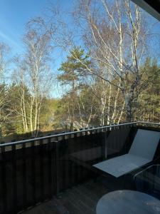 ein Balkon mit Tisch und Blick auf Bäume in der Unterkunft Aura Nida in Neringa