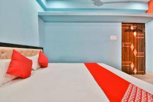 a bedroom with a bed with red pillows at Hotel O Magadh Imperial in Patna