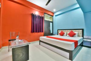a bedroom with orange and blue walls and a bed at Hotel O Magadh Imperial in Patna +22 photos